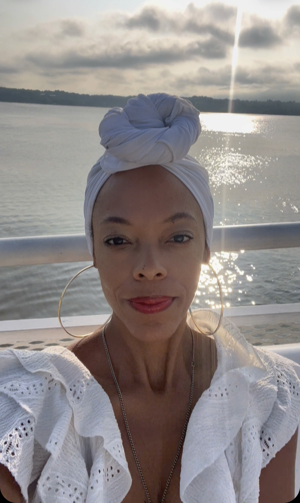 A photo of Gogo smiling in a white headwrap on the water.